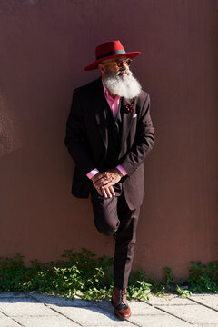 Stylish mature man leaning against a wall outside