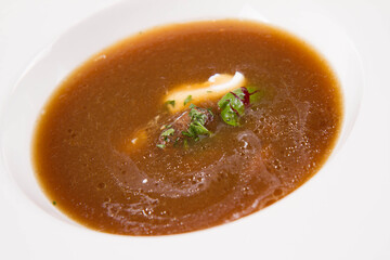 Mushroom soup served with some cream, mushrooms and parsley
