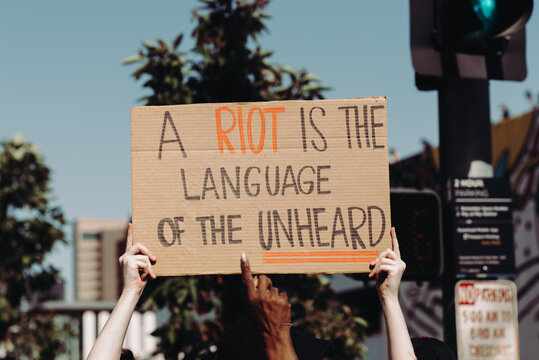 Hands Holding Cardboard Sign At Protest