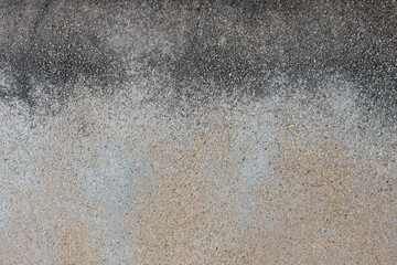 Grey cement wall partially painted with white paint