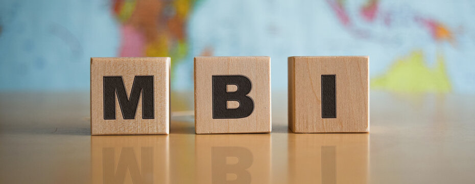 The inscription MBI on wooden cubes, isolated, on the background of a political map.