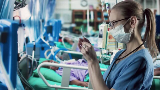 Medicine, technology and healthcare concept - female doctor or nurse with medical syringe in at hospital ward