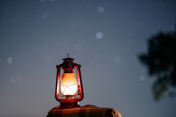 Fototapeta na wymiar old red petrol lamp in the night. stars background