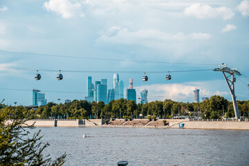 View of the funicular across the river, a city with skyscrapers in the background