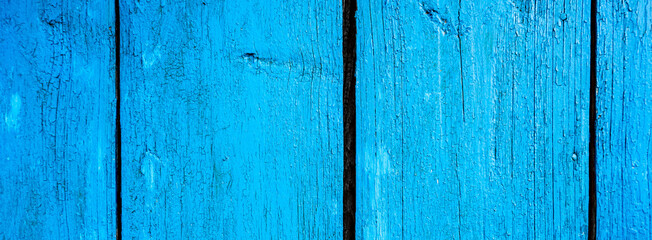 Wooden protection on all background, is painted light blue. old cracked blue paint on wood flooring.