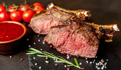 Baked beef on the bone with spices on a stone background