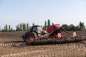 Tractor cultivating soil and preparing a field for planting