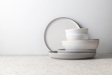 A stack of beautiful plates on a light background, beautiful light from the window