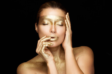Beauty woman face with gold mask. Gold based skincare concept. Cosmetology and spa treatment