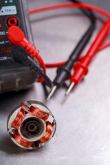 Damaged electric motor rotor and electric meter. Measurement work in an electrical workshop.
