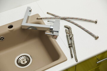 kitchen faucet replacement concept. mixer and hoses near the sink