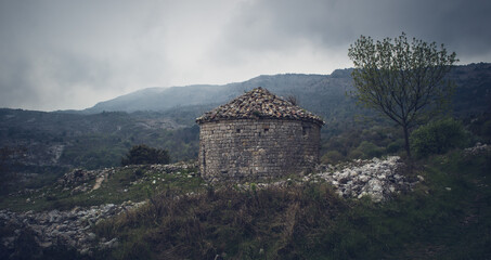 Stone chapel in the mountains in the south of France on a cloudy day.