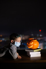 Sad boy celebrating halloween alone social distance. A child in a mask on the eve of all saints day. Kid in a protective medical mask. Covid-19 coronavirus pandemic 2020. treat or trick  no party