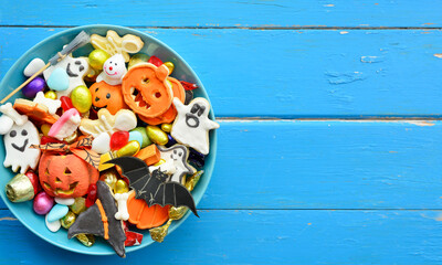 happy halloween card background, Jack o Lantern candy bowl with sweets and halloween cookies Trick or Treat surrounded by festive decor spiders, bats, skull