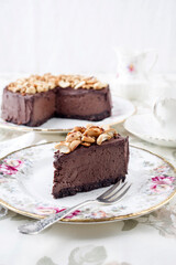 Fototapeta na wymiar Traditional chocolate pie with cashew nuts offered as close-up on a design bone China plate