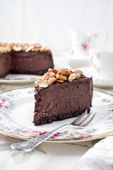 Traditional chocolate pie with cashew nuts offered as close-up on a design bone China plate