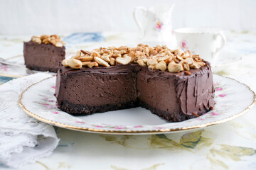 Traditional chocolate pie with cashew nuts offered as close-up on a design bone China plate