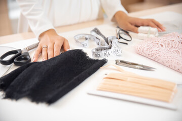 Step 1 process of sewing underwear and clothes, woman tailor cuts blanks for panties from black lace