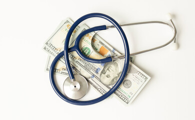 Envelope with money and a stethoscope on wooden background