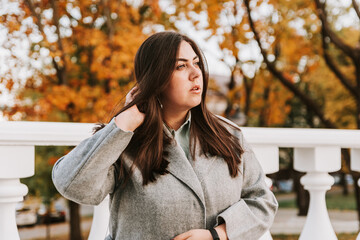 Portrait of a beautiful adult young woman on the background of autumn in the Park