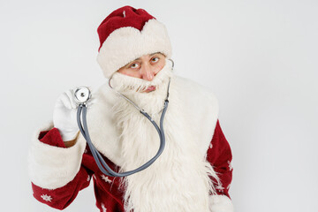 Santa Claus holds a stethoscope in his hand. Isolated on white