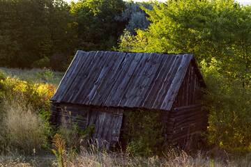 A wooden shed made of aged wood, which has become gray from old age. - 384883589