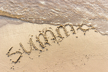 Summer written on the sandy shore. Summer ended and was washed away by a wave. Summer background. - 384883711