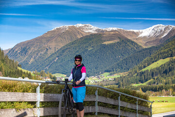 Fototapeta na wymiar Italy, South Tyrol, Pustertal, Bruneck, Portrait of woman riding an E-Mountain bike