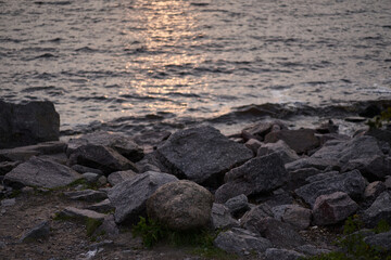 Fototapeta na wymiar rocky beach by the water at sunset or dawn