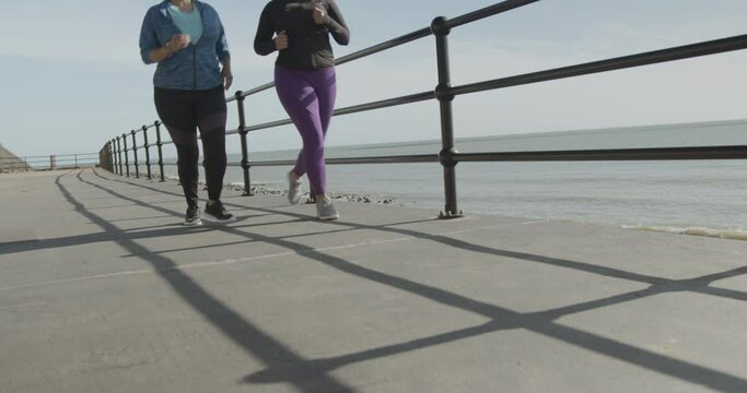 Two plus size females exercising outdoors, Obese black women sports training body positive