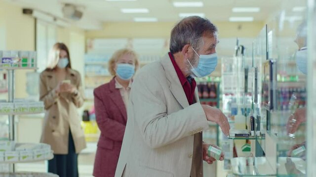 People standing in line in the pharmacy. In medical masks. Inside. Quarantine safety pandemic sick doctor buy infection drugstore respiratory. Slow motion
