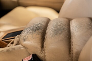 Old cracked damaged leather on car leather upholstery.