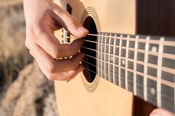 Fototapeta premium Man's hands playing an acoustic guitar