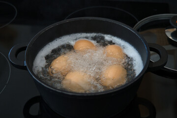 Fünf Bio Frühstückseier, Hühnereier kochen im Wasserbad	
