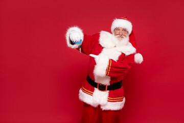 Happy Santa Claus with house keys as a gift.