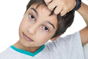 a dark-haired boy with black eyes touches his hair