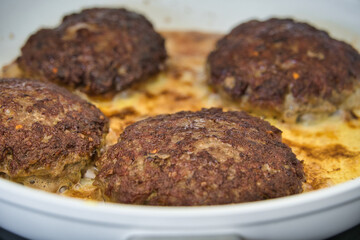 Frikadellen Gemüse Fleisch Paddys mit Kurkuma beim Anbraten in weißer Teflonpfanne mit Kokosöl, Produktbild	
