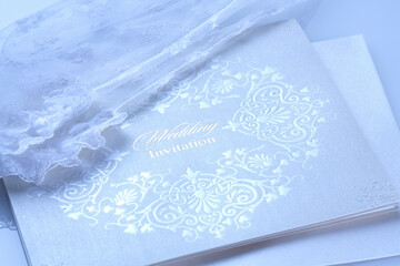 結婚式の招待状と新婦のレースの白い手袋