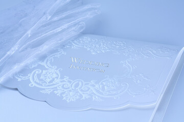 結婚式の招待状と新婦のレースの白い手袋