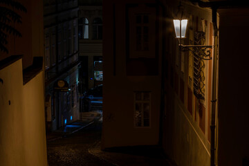 street lamp and sidewalk with cobblestones and light reflections after the rain in the center of the old town of Prague in the Czech Republic