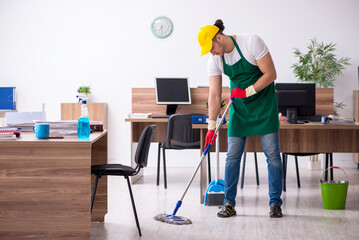 Young male contractor cleaning the office