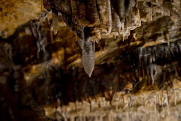 Stalactites and stalagmites inside natural limestone cave. Natural formations.