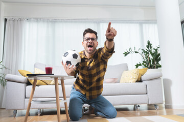 Football fan celebrating victory at home