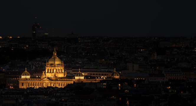 view of the roofs of buildings in the city of prague and the enlightened national museum from 1818 in the czech republic at night