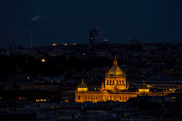 Fototapeta premium view of the roofs of buildings in the city of prague and the enlightened national museum from 1818 in the czech republic at night