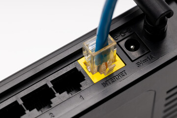 close up internet plug at back side of a wifi router device. internet access hardware