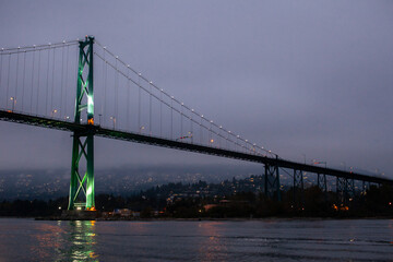 A view of the Lion's Gate Bridge connecting Vancouver to the North Shore through Stanley Park, over English Bay in British Columbia, at night.