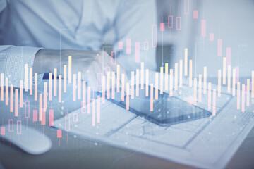 Double exposure of man's hands holding and using a digital device and forex graph drawing. Financial market concept.