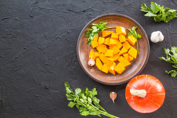 Beautifully chopped pumpkin slices, herbs, and ingredients for the dish. Creative atmospheric decoration