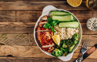 Keto lunch bowl. Grilled chicken with cauliflower rice, broccoli and cucumber.